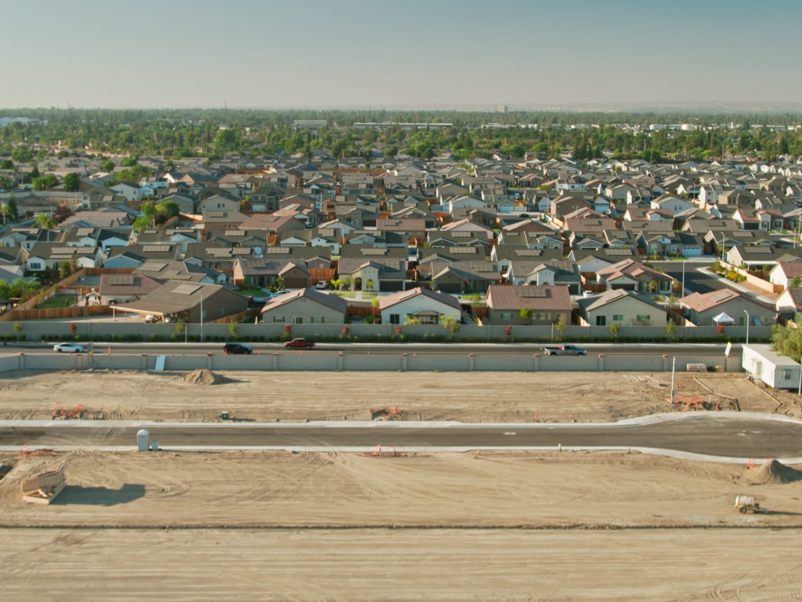Drone shot flying over land graded for new construction and established residential streets on the edge of Bakersfield, California, where the suburbs are encroaching onto Central Valley farmland. 

Airspace authorization was obtained from the FAA for this operation.
